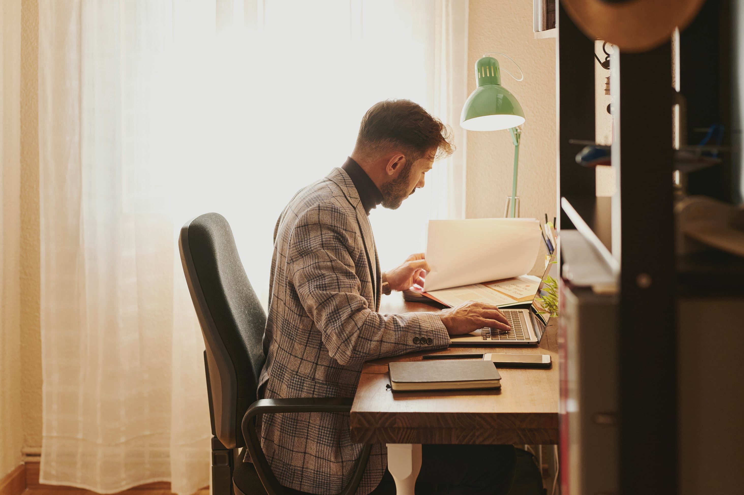 A self-employed professional working at a home office desk