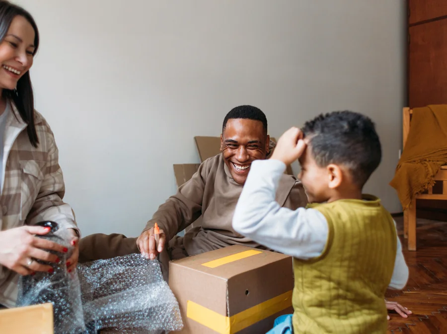 A family unpacking moving boxes in their new home